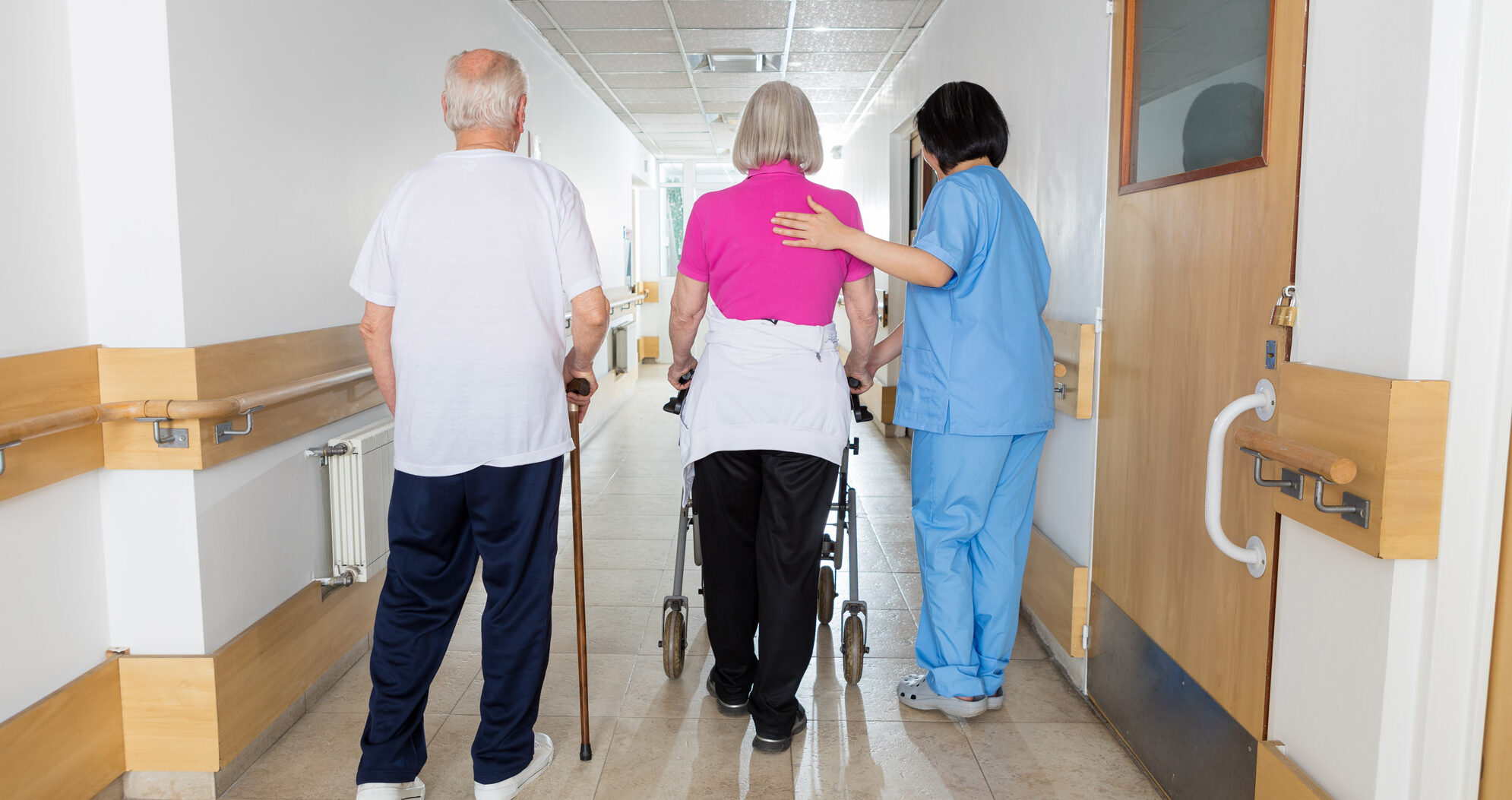Seniors walking in a retirement home with nurse