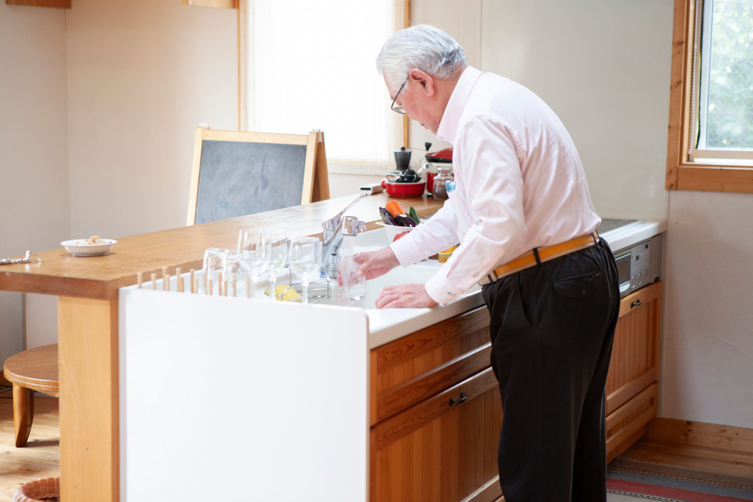 Independant senior cleaning dishes in his kitchen