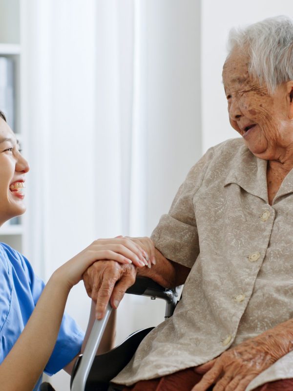 Young Asian woman, nurse, caregiver, carer of nursing home talking with senior Asian woman feeling happy at home